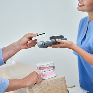 A patient paying the cost of dental implants