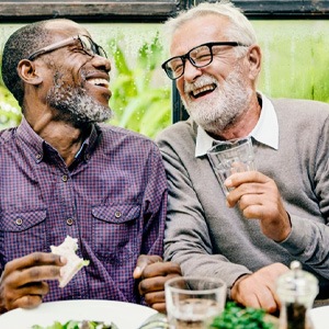 two men laughing and eating healthy foods  