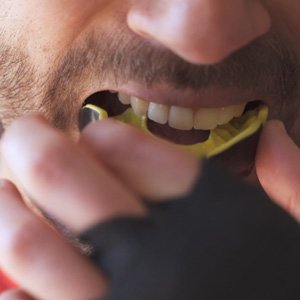 man putting a mouthguard in his mouth   