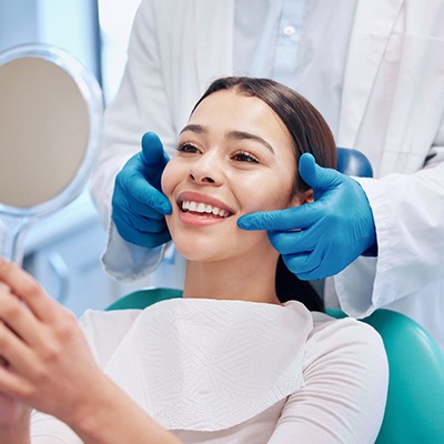 Happy dental patient looking in mirror