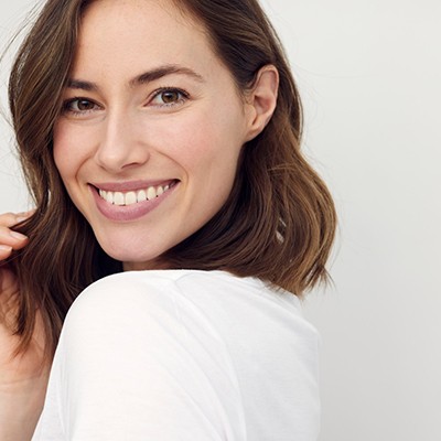 Woman with beautiful teeth smiling over her shoulder