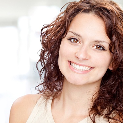 Brown-haired woman standing up and smiling