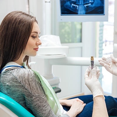 dentist showing patient an implant