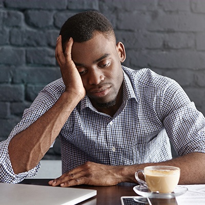 man with coffee really tired