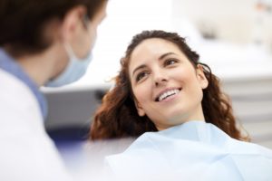 Woman smiling in dental chair looking at dentist