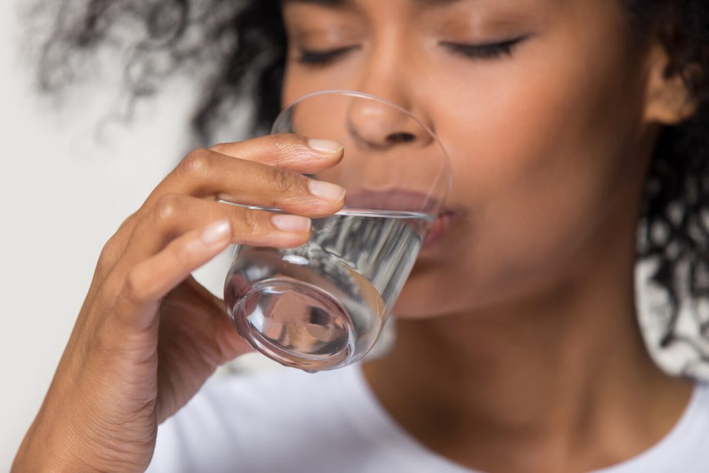 person drinking water to prevent winter mouth issues in Bradford