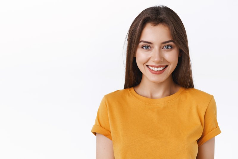 person smiling after replacing missing back tooth